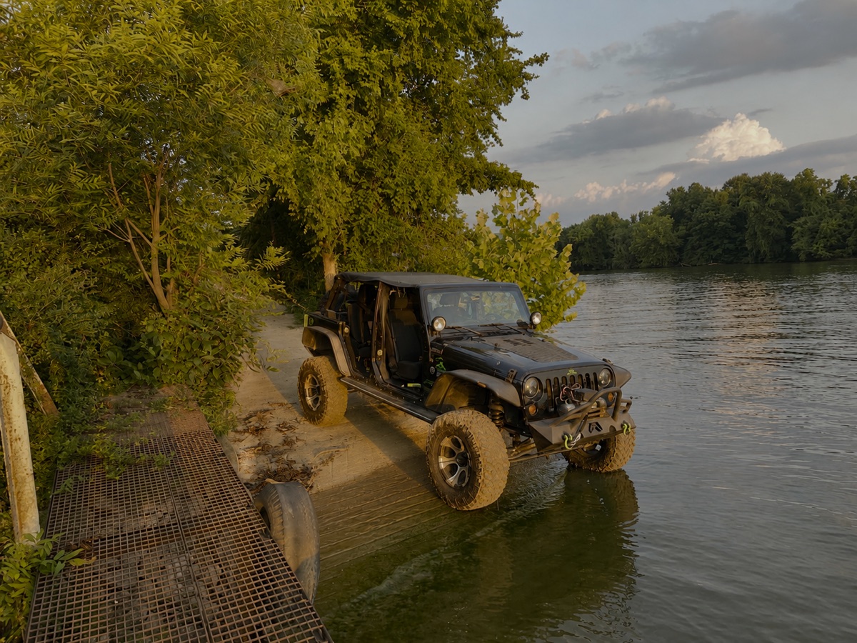 John's Jeep easing down a muddy trail to the Tennessee River at golden hour